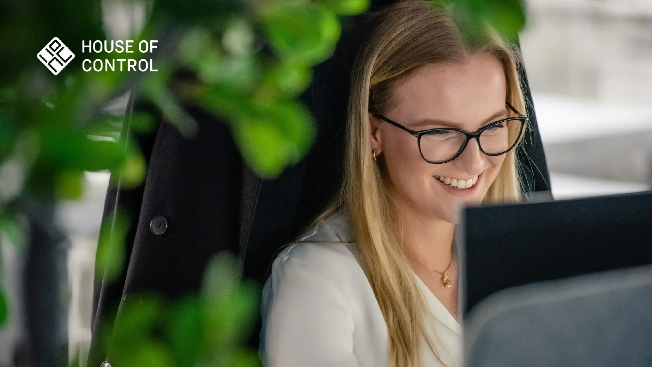 A House of Control employee looking at a screen smiling