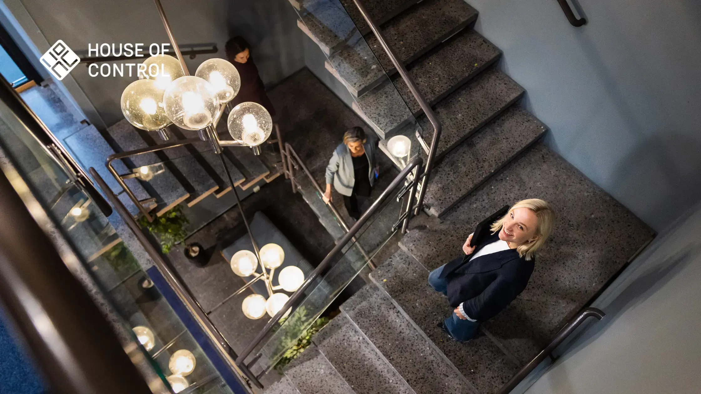 An employee at House of Control walking down a set of stairs smiling