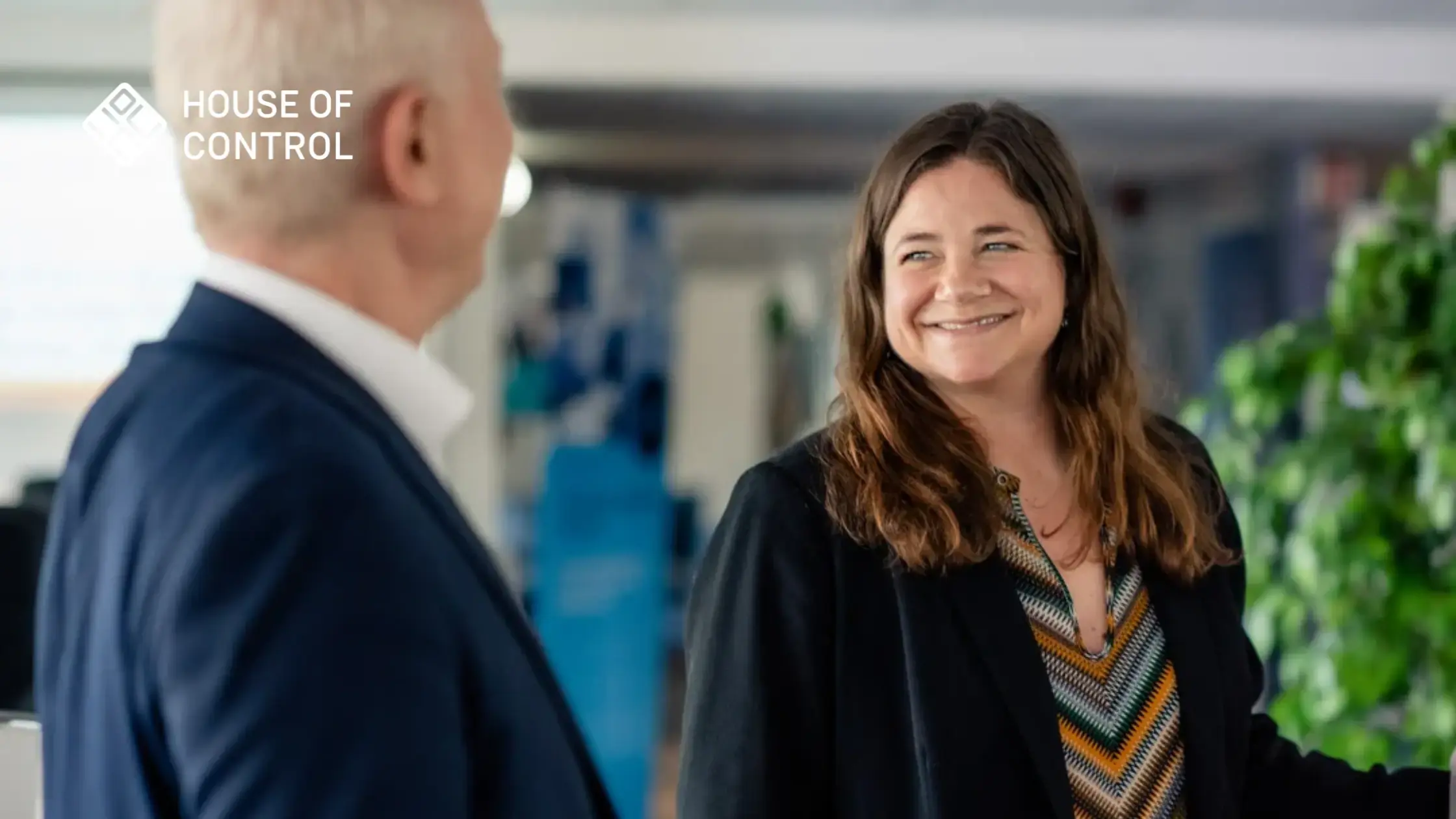 Two colleagues at House of Control having a friendly discussion while smiling